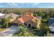 Aerial view of home featuring a three-car garage, tile roof, and mature landscaping at 6977 74Th Street E Cir, Bradenton, FL 34203