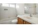 Bright bathroom featuring wood vanity, white sink, toilet, and tiled tub/shower combination at 6977 74Th Street E Cir, Bradenton, FL 34203