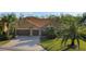 Stunning tile roof with an elegant tan exterior, spacious three car garage, and lush landscaping at 6977 74Th Street E Cir, Bradenton, FL 34203