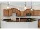 Bright kitchen with dark countertops, wood cabinets, and pendant lighting at 6977 74Th Street E Cir, Bradenton, FL 34203