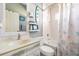 Well-lit bathroom with white vanity, tub and shower combo, and coastal-themed decorations at 2734 Ashland Ln, North Port, FL 34286