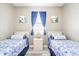 Comfortable bedroom featuring two twin beds, nautical themed decor, and a calming color palette at 2734 Ashland Ln, North Port, FL 34286