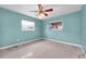 A light blue bedroom has two windows with mini blinds and a ceiling fan with lighting at 2817 Miriam S St, Gulfport, FL 33711