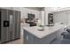 Close-up of kitchen island with gray cabinets, white countertops, and stainless steel appliances at 3083 Sikeston Ave, North Port, FL 34286