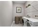 Cozy laundry room with a white washer and dryer, natural fiber baskets and open shelving at 3083 Sikeston Ave, North Port, FL 34286