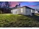 Angle shot of the house's back with a concrete patio and lush green lawn at 3083 Sikeston Ave, North Port, FL 34286