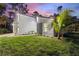 Modern home with a vibrant lawn, palm tree, and stylish exterior accents at dusk at 4044 Simkins Ave, North Port, FL 34286