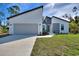 Modern home with a stylish gray and white exterior, two-car garage, and freshly installed landscaping at 4044 Simkins Ave, North Port, FL 34286