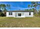 View of the back of the house, which features a covered patio and sliding glass doors for indoor/outdoor living at 4044 Simkins Ave, North Port, FL 34286