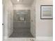 Modern glass enclosed shower featuring gray tile walls, built in niche and dark floor at 4044 Simkins Ave, North Port, FL 34286