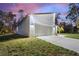 A view of the home's side exterior at dusk, showcasing clean lines, a two-car garage, and well-maintained lawn at 4044 Simkins Ave, North Port, FL 34286