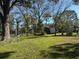 Spacious green backyard surrounded by mature trees and a partial fence, providing privacy at 7306 Jones Rd, Odessa, FL 33556