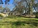 Spacious green backyard with mature trees around the exterior of the property at 7306 Jones Rd, Odessa, FL 33556