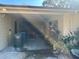 Image of the carport area, with a parked vehicle and storage racks at 7306 Jones Rd, Odessa, FL 33556