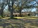 Single-story home with a large front yard and a chain-link fence surrounding the property at 7306 Jones Rd, Odessa, FL 33556