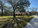 Home exterior with a wide lawn and mature trees adding curb appeal and natural shade at 7306 Jones Rd, Odessa, FL 33556