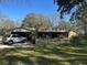 Home exterior featuring a garage, a car in the driveway and a fenced yard at 7306 Jones Rd, Odessa, FL 33556