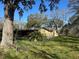 Exterior view of home featuring mature trees and partial fencing at 7306 Jones Rd, Odessa, FL 33556