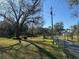 Expansive front yard with mature trees and green grass leading up to the residential area at 7306 Jones Rd, Odessa, FL 33556