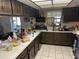 Picture of the kitchen area with wood cabinets, white counters, and stainless steel appliances at 7306 Jones Rd, Odessa, FL 33556