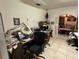 View of the office space featuring a black office chair, tiled floors, and visible clutter on the desk at 7306 Jones Rd, Odessa, FL 33556