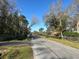 Neighborhood street with mature trees and utility pole at 7306 Jones Rd, Odessa, FL 33556