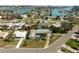 Aerial view of a home with a swimming pool in a waterfront community with many palm trees at 10111 Yacht Club Dr, Treasure Island, FL 33706