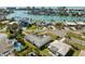Aerial view of a waterfront home with a swimming pool surrounded by palm trees and other houses at 10111 Yacht Club Dr, Treasure Island, FL 33706