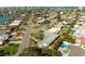 Aerial view of a waterfront community with houses, palm trees, swimming pools, and boat docks at 10111 Yacht Club Dr, Treasure Island, FL 33706