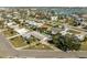 Aerial view of a waterfront community with houses, swimming pools, palm trees, and waterfront access at 10111 Yacht Club Dr, Treasure Island, FL 33706