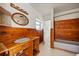 Retro bathroom features wood paneled walls and cabinetry, with a sink and bathtub at 10111 Yacht Club Dr, Treasure Island, FL 33706