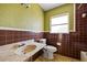This bathroom has brown and white tile walls, a marble sink, and toilet at 10111 Yacht Club Dr, Treasure Island, FL 33706