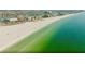 Panoramic aerial view of a pristine beach with white sand meeting the clear turquoise ocean water at 10111 Yacht Club Dr, Treasure Island, FL 33706