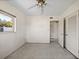 This bedroom has a ceiling fan, closet with white louvered doors, and a window for natural light at 10111 Yacht Club Dr, Treasure Island, FL 33706