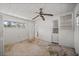 Bedroom with tiled ceiling, ceiling fan, window, built-in shelving, and an unfinished floor at 10111 Yacht Club Dr, Treasure Island, FL 33706