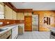 Wood-paneled kitchen featuring classic cabinetry, white appliances, and tile flooring at 10111 Yacht Club Dr, Treasure Island, FL 33706