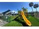 Fun playground featuring a yellow slide and climbing structures, set on artificial turf at 10111 Yacht Club Dr, Treasure Island, FL 33706