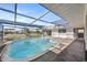 Bright screened-in pool with clear water, surrounded by a patio and view of manicured landscaping at 10111 Yacht Club Dr, Treasure Island, FL 33706