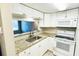 The kitchen featuring bright cabinets, granite counters and stainless appliances at 7113 E Bank Dr # 7113, Tampa, FL 33617