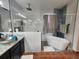 Modern bathroom featuring a soaking tub, glass-enclosed shower, a vessel sink, and decorative tiling at 10327 Meadow Crossing Dr, Tampa, FL 33647