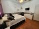 This bedroom features tiled floors, neutral colored walls and trim, a ceiling fan and a mounted television at 10327 Meadow Crossing Dr, Tampa, FL 33647