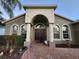 Inviting home entrance featuring arched doorway, columns, and meticulously landscaped garden at 10327 Meadow Crossing Dr, Tampa, FL 33647