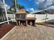 Outdoor kitchen featuring a built-in grill, storage, and ample counter space on a brick patio at 10327 Meadow Crossing Dr, Tampa, FL 33647