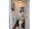 This quaint powder room offers terra cotta flooring, a toilet, and a decorative gallery wall at 10327 Meadow Crossing Dr, Tampa, FL 33647