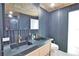 Modern bathroom featuring a dual sink vanity, a black accent wall and wood-look ceiling at 4760 Meredith Ln, Sarasota, FL 34241