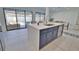 Contemporary kitchen island boasts navy cabinets, white countertops, and views of the outdoor pool at 4760 Meredith Ln, Sarasota, FL 34241