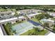 Aerial view of condo complex featuring a tennis court, pool, parking, and meticulously maintained landscaping at 12300 Vonn Rd # 7203, Largo, FL 33774