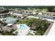 Aerial view showcases pool, tennis courts, and lush landscaping of the condo community at 12300 Vonn Rd # 7203, Largo, FL 33774