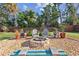 Landscaped backyard features gravel, a fire pit, decorative plants, and a wood fence at 1321 Groveland Ave, Venice, FL 34285