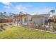 Backyard with lush lawn, wooden pergola, patio furniture and desert themed landscape at 1321 Groveland Ave, Venice, FL 34285